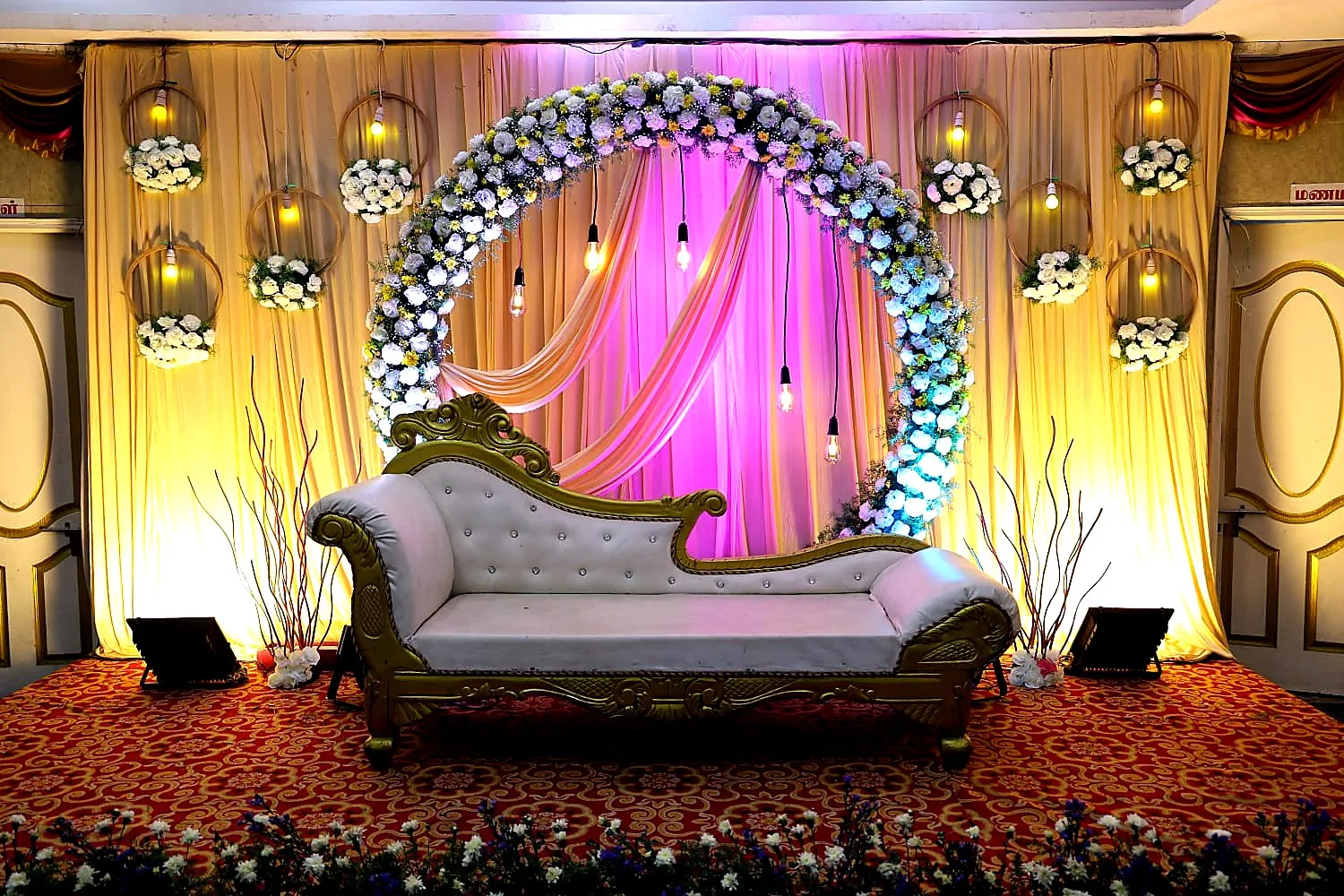 Close view of a crystal bridal sofa under a circular flower arch on a Chennai wedding stage